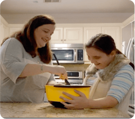 patient Alison cooking with young girl