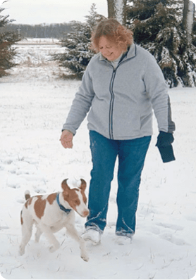 patient Ronda playing with dog in the snow