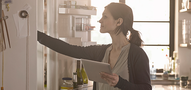 actor portrayal of woman grabbing food in the refrigerator